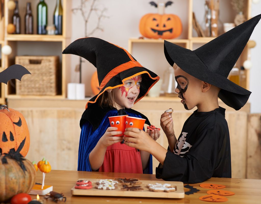 A couple of kids enjoying some Halloween treats.