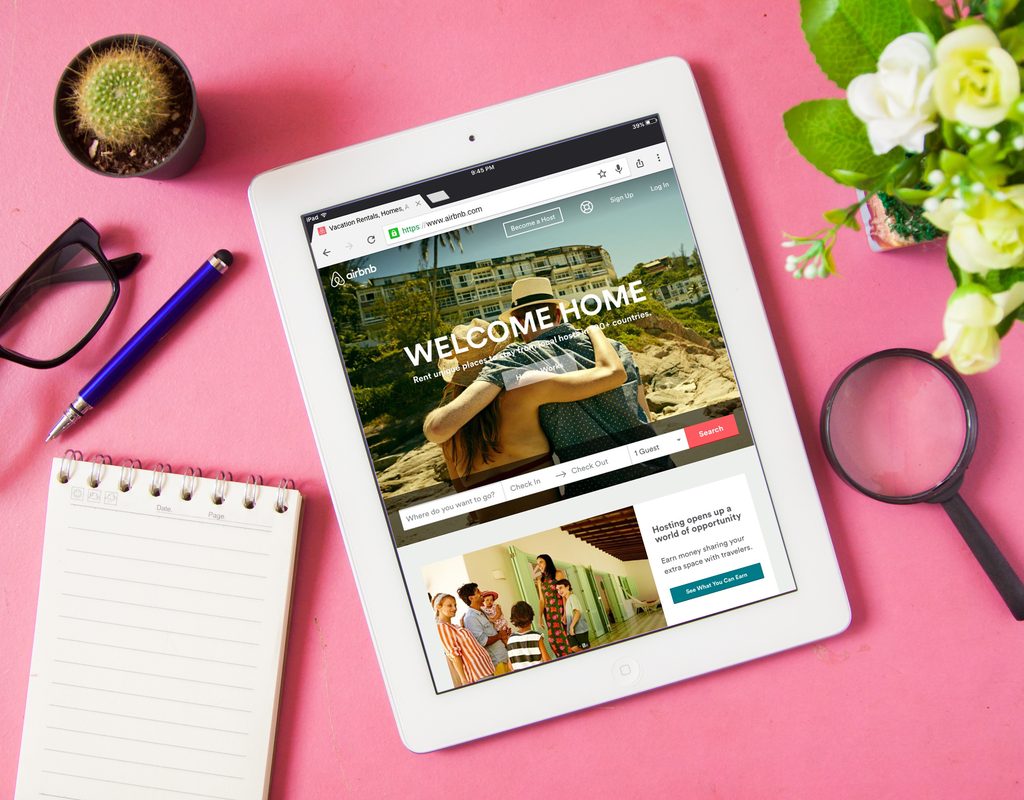 A tablet and other office items on a pink background.