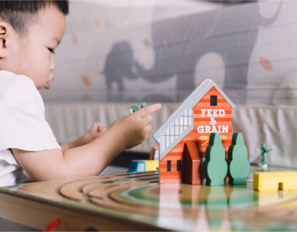 Toddler boy having fun with farm toys