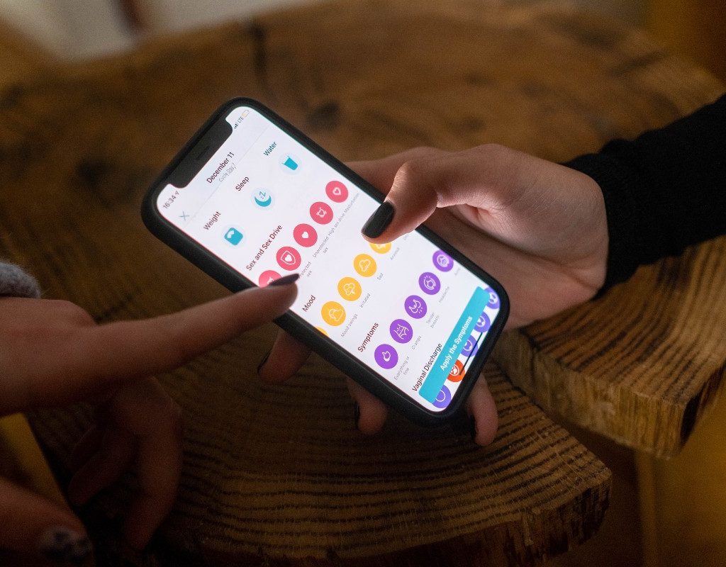woman putting data into a menstrual cycle app