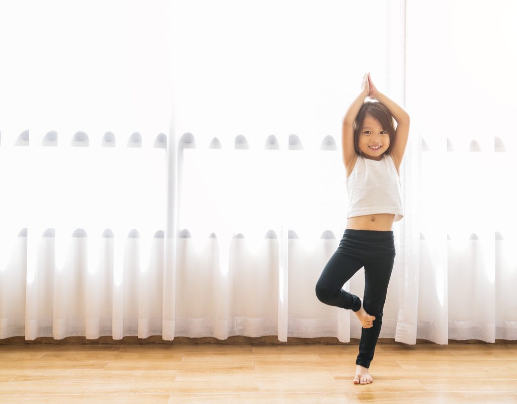 little girl doing yoga poses as an exercise warm-up