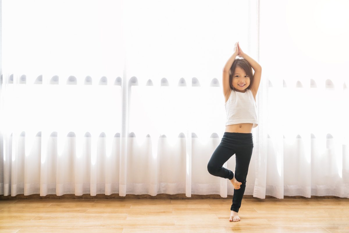 Little girl doing yoga poses as an exercise warm-up.