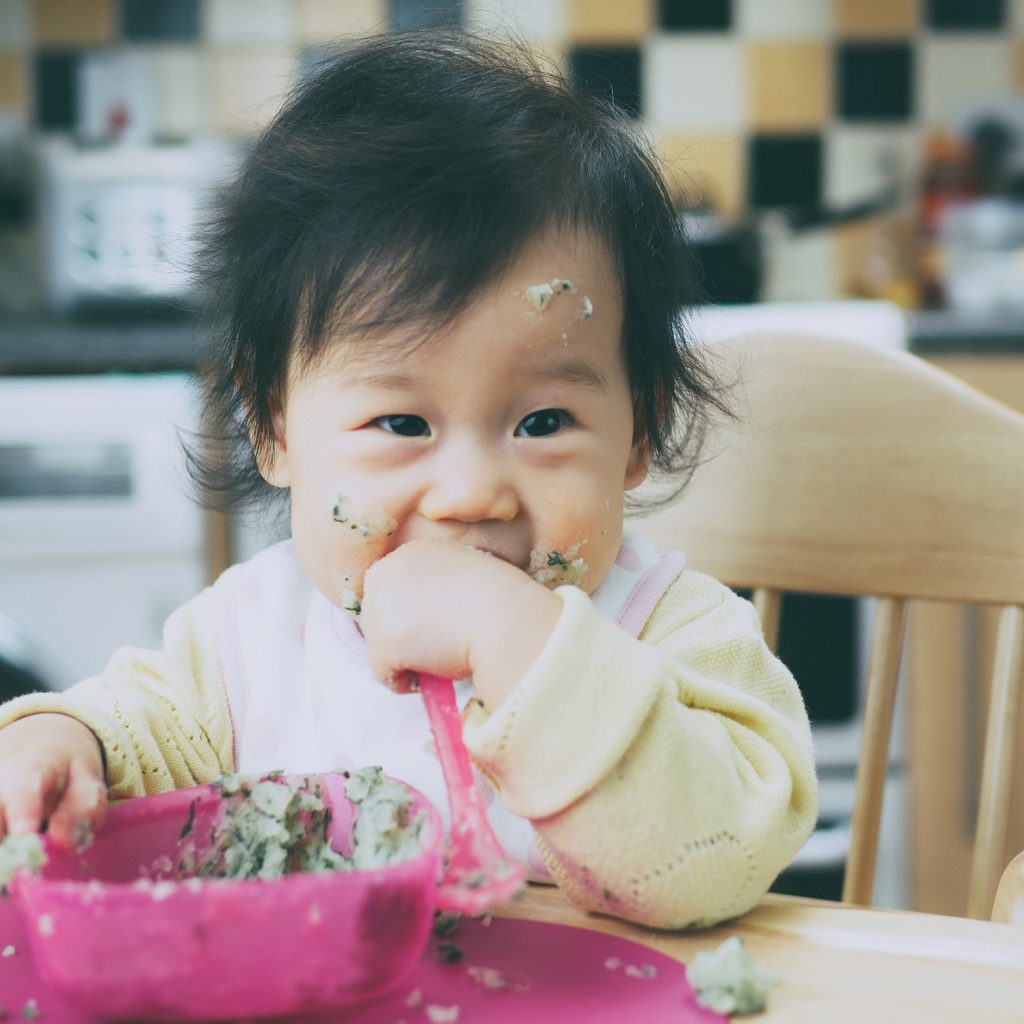 A child in a high chair to eat.