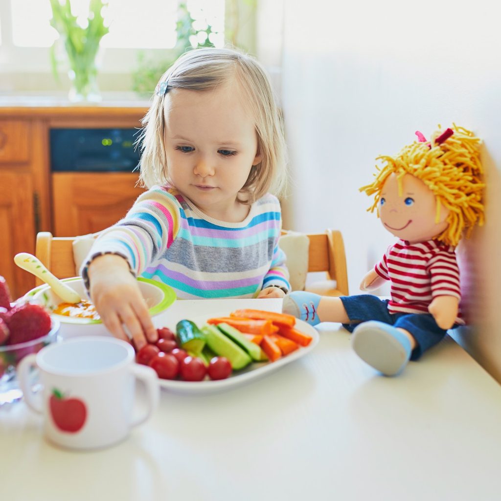 Little girl eating a plate of vegetables