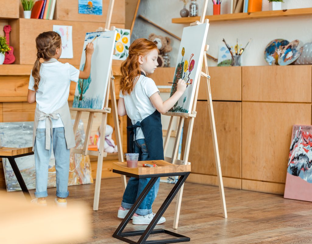 Two kids having fun painting at an art-themed birthday party