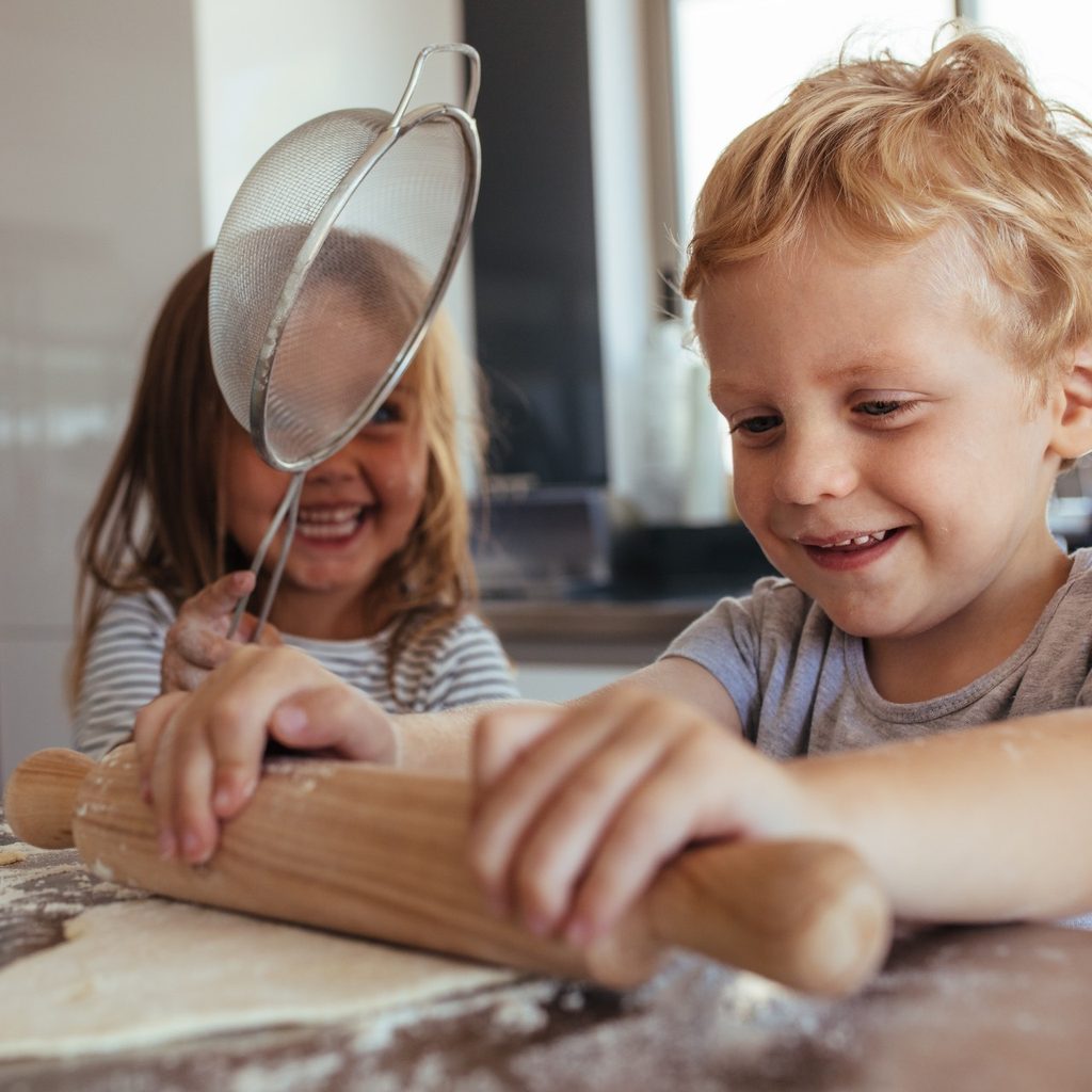 Little kids rolling dough