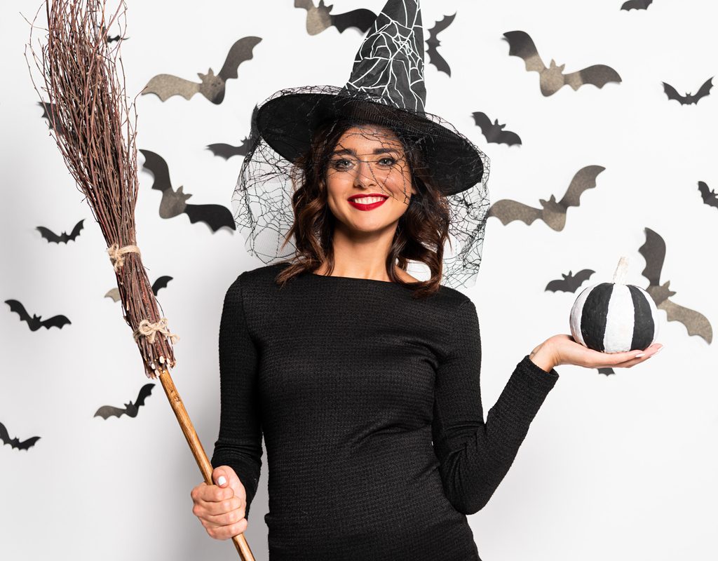 Happy pregnant mom wearing a maternity witch costume for Halloween