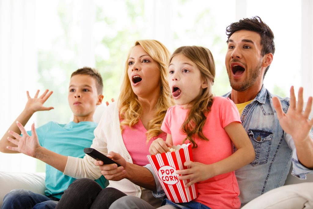 Family watching television in living room