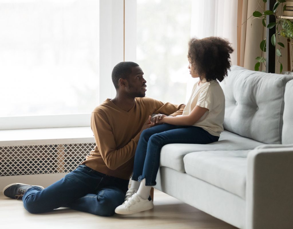 A father comforting and talking to his daughter.