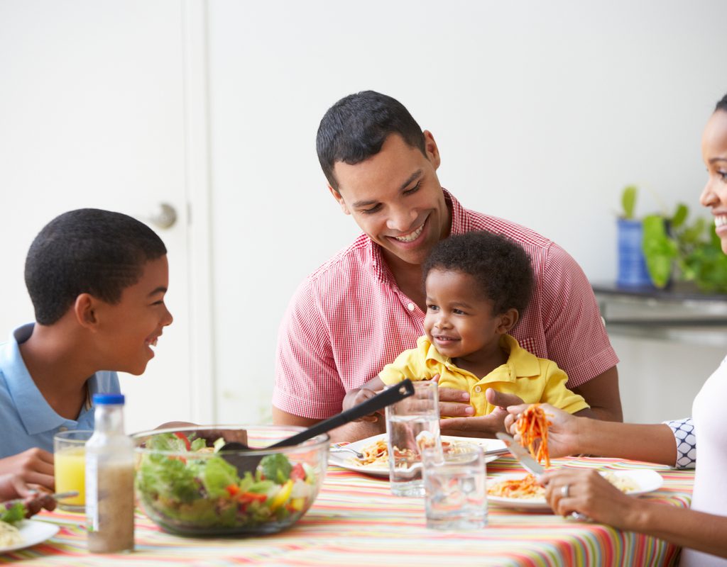 A family with a toddler sitting down to dinner
