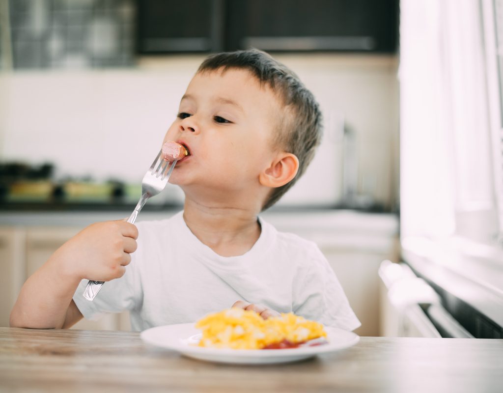 A toddler eating his dinner.