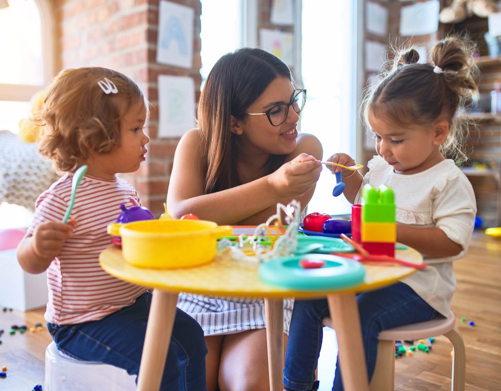 A mom feeding her toddlers.