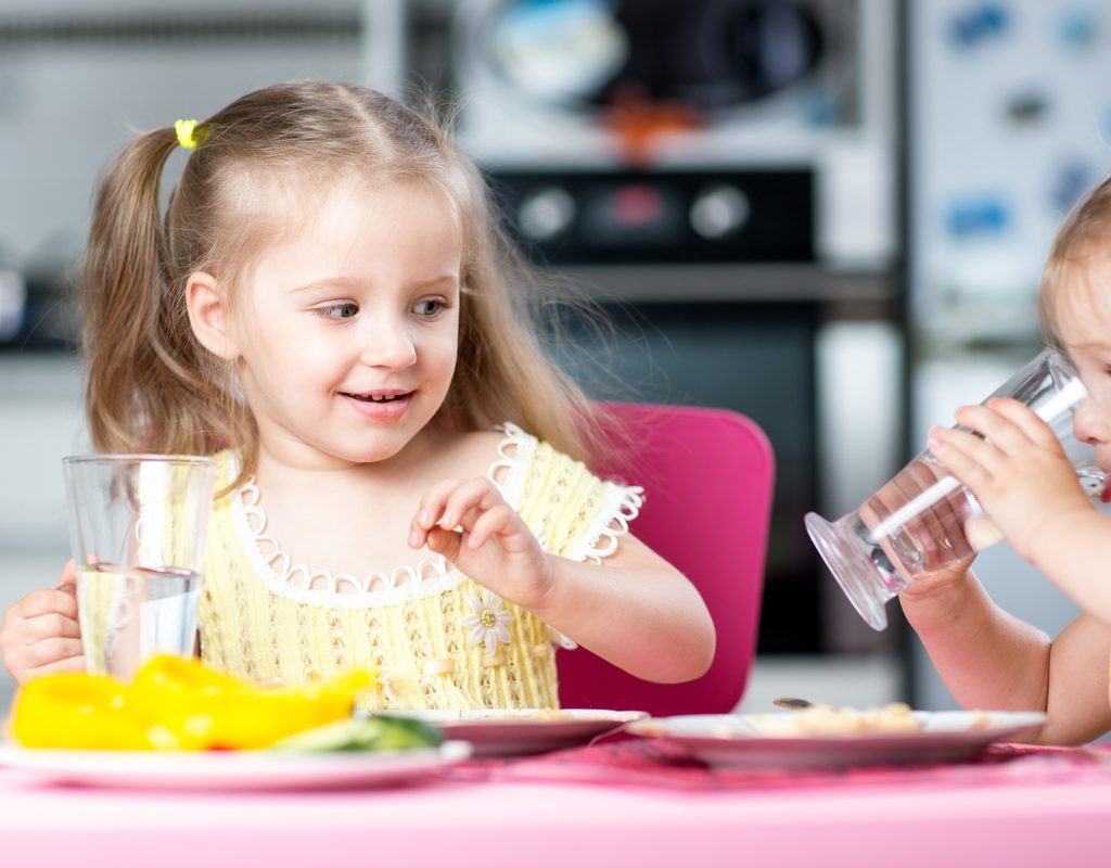 A couple of toddlers drinking water.