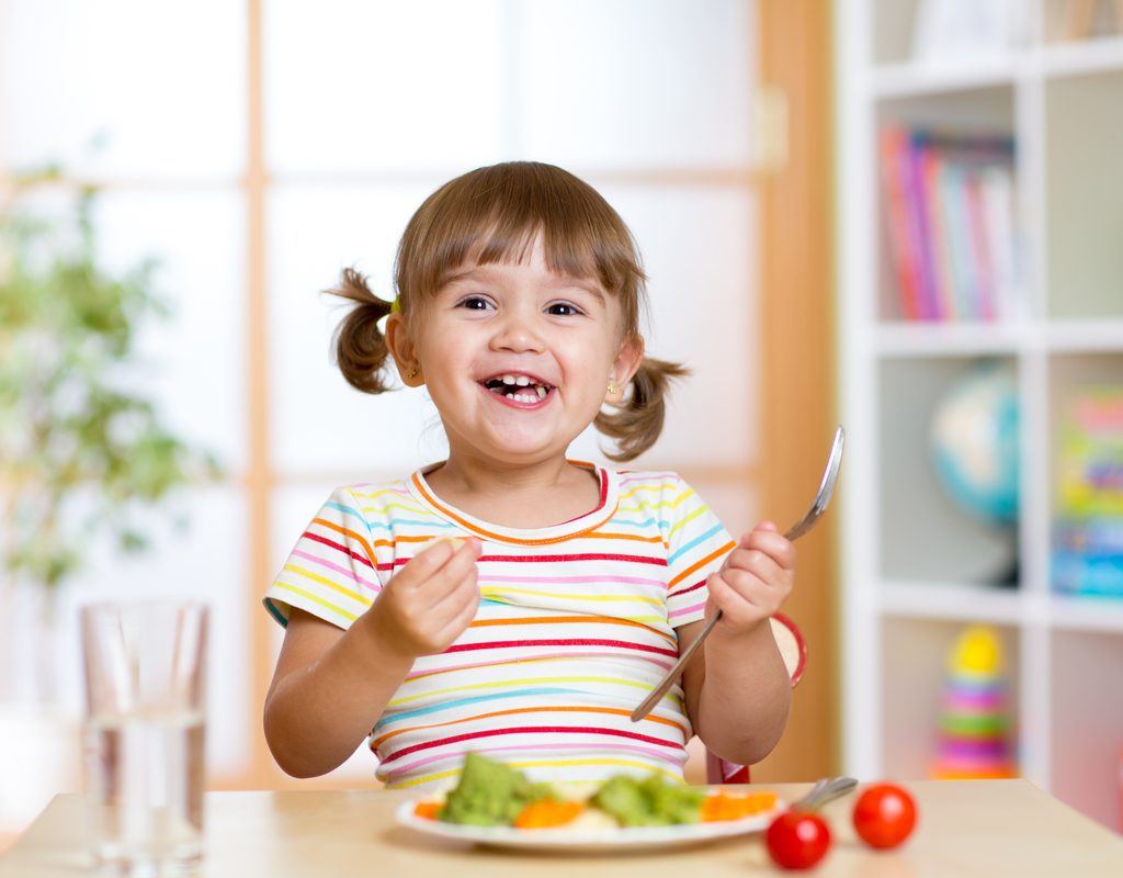 A young girl enjoying her dinner.