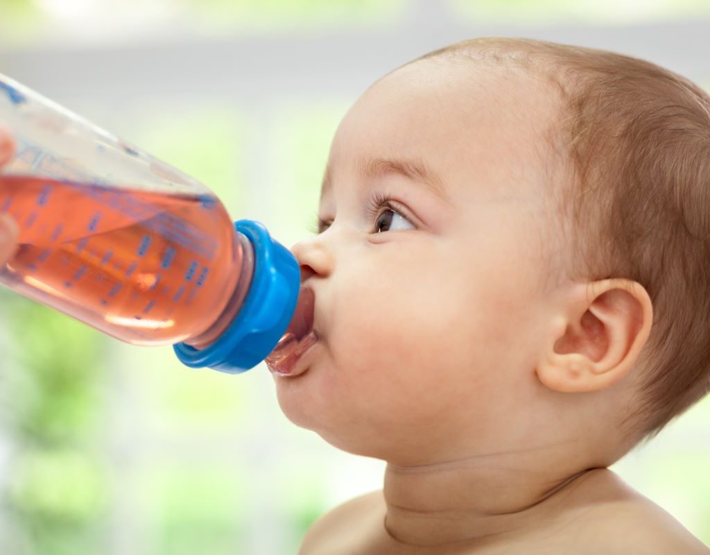 Baby drinking out of a bottle.