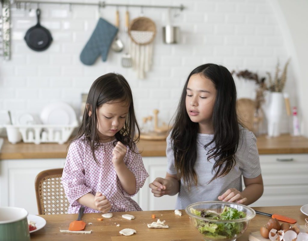 Two children are making a snack in the kitchen.