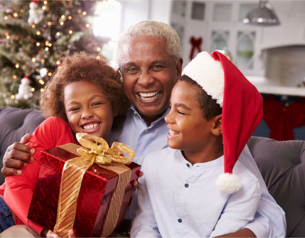 Grandpa opening gifts with his grandkids