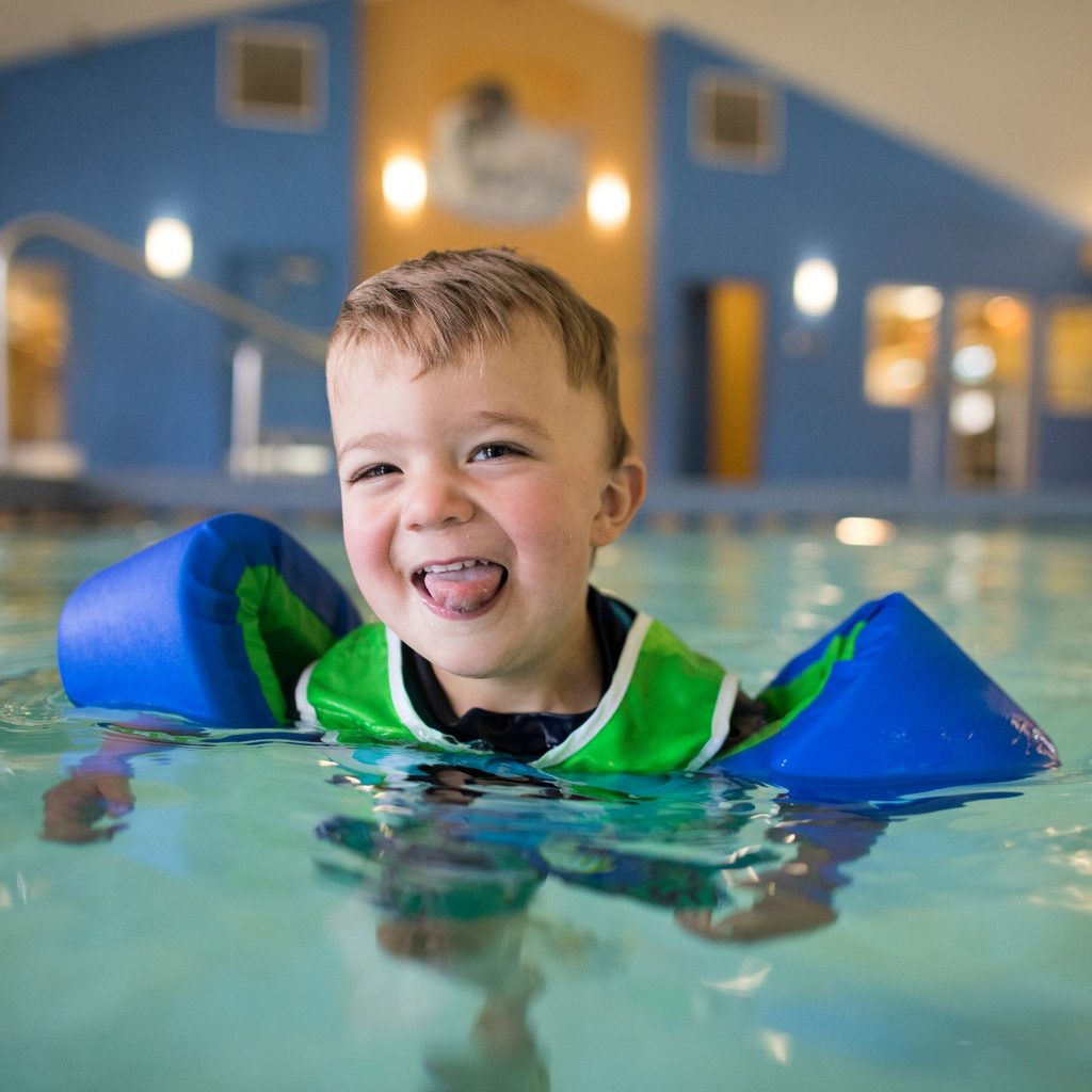 Small child swimming with floaties