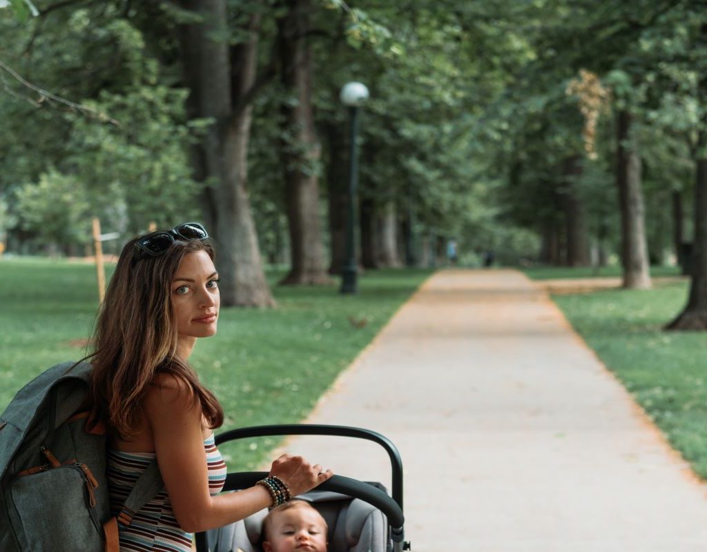 Mom with backpack with baby in a stroller