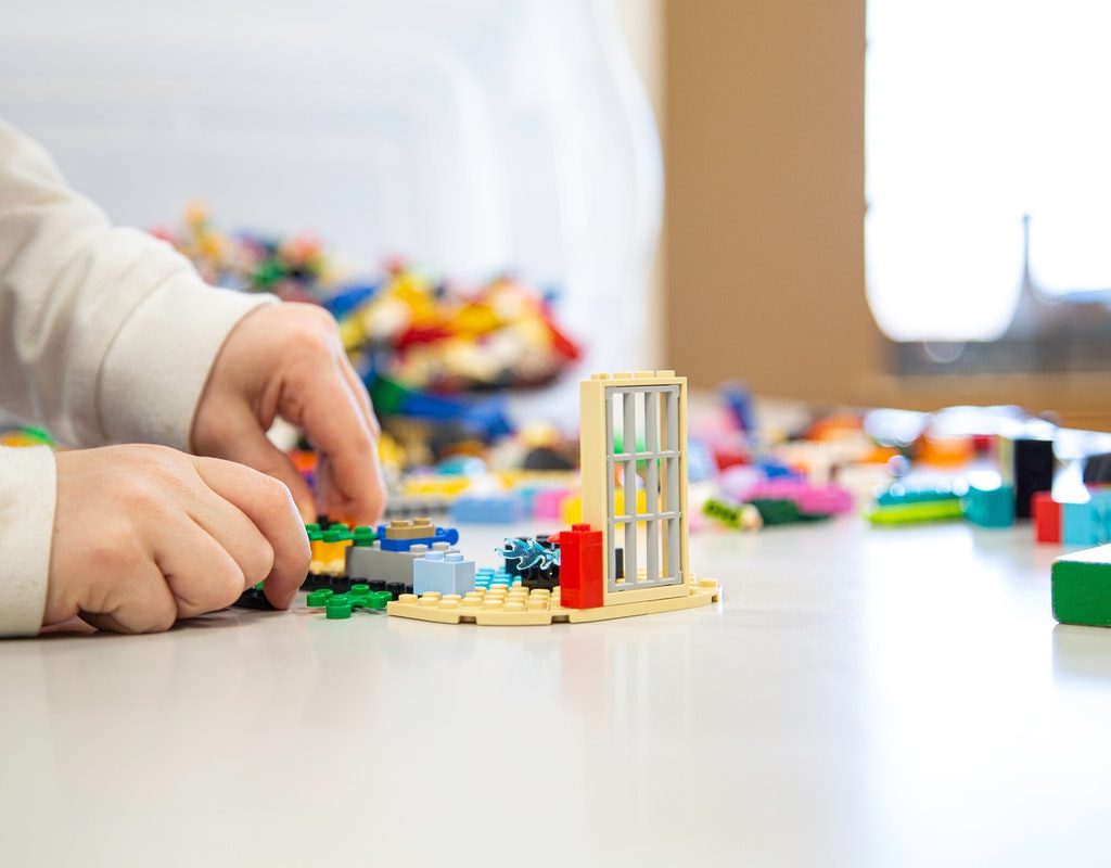 A child's hands playing with LEGO.
