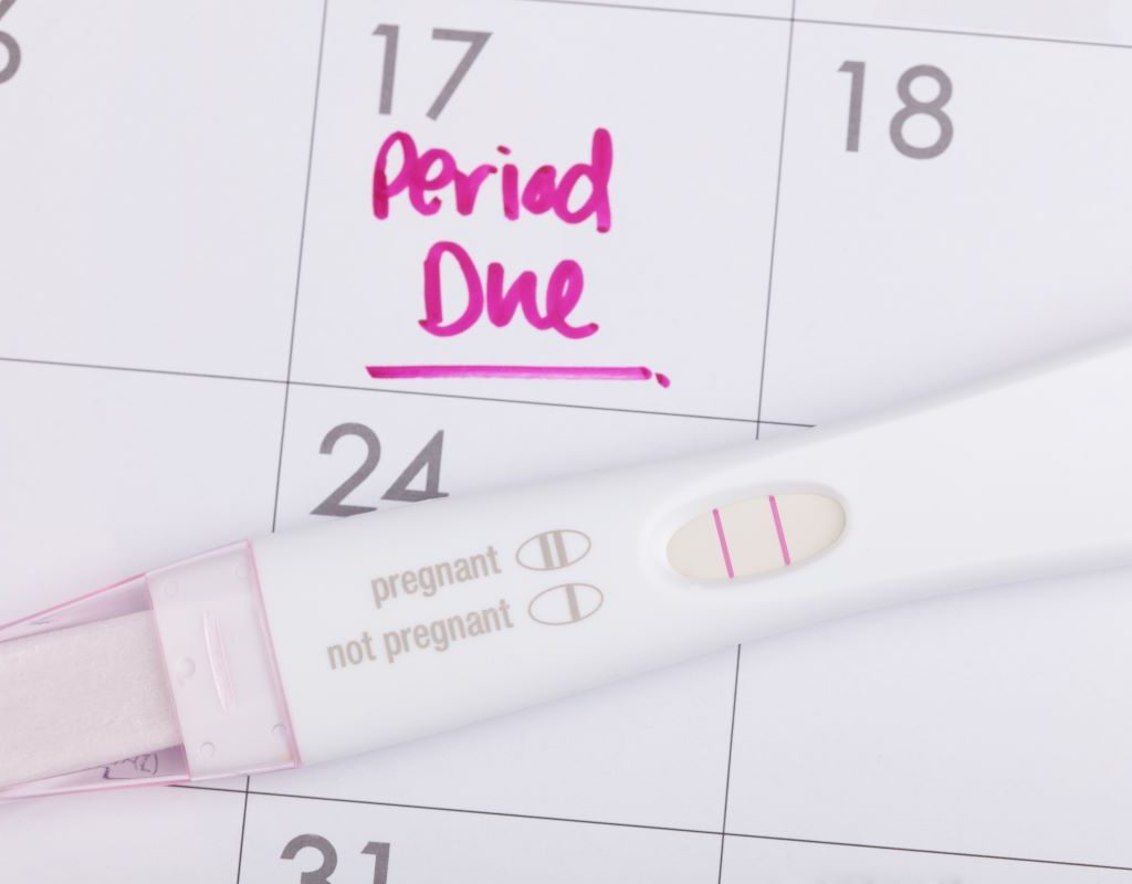 pregnancy test on top of a calendar