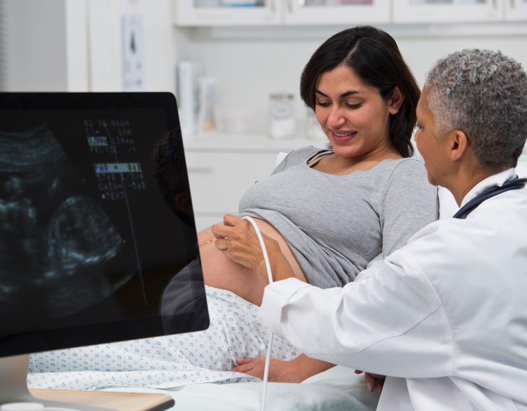 Sonographer performing an ultrasound on an expecting mom