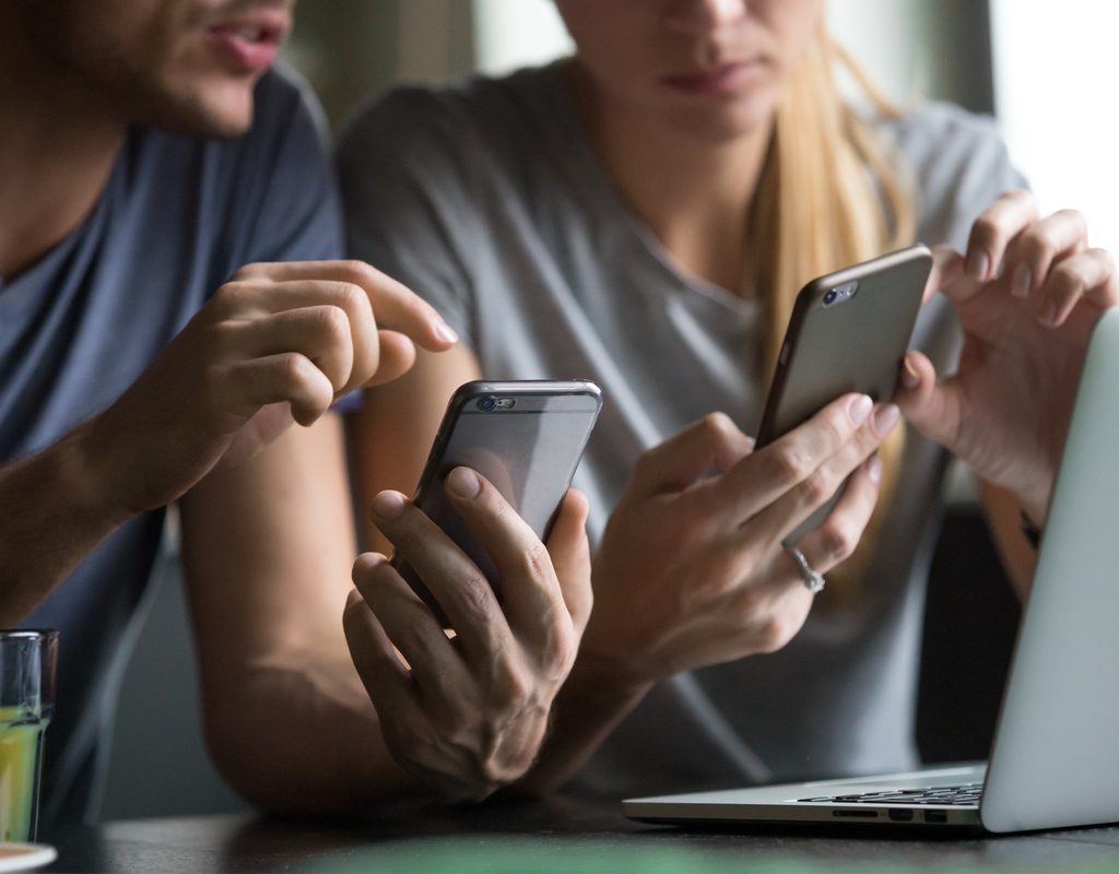 couple using family money saving app on their smartphones