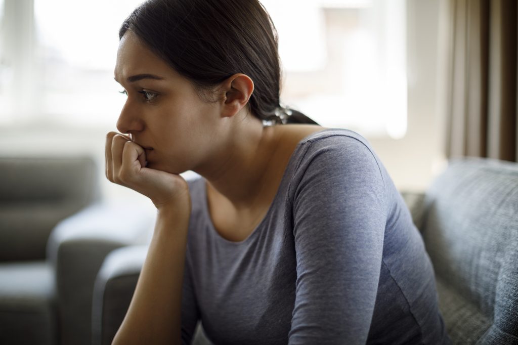 Worried woman sitting on the couch