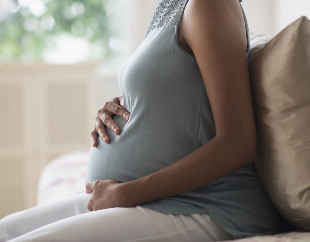 Pregnant woman cradling baby bump
