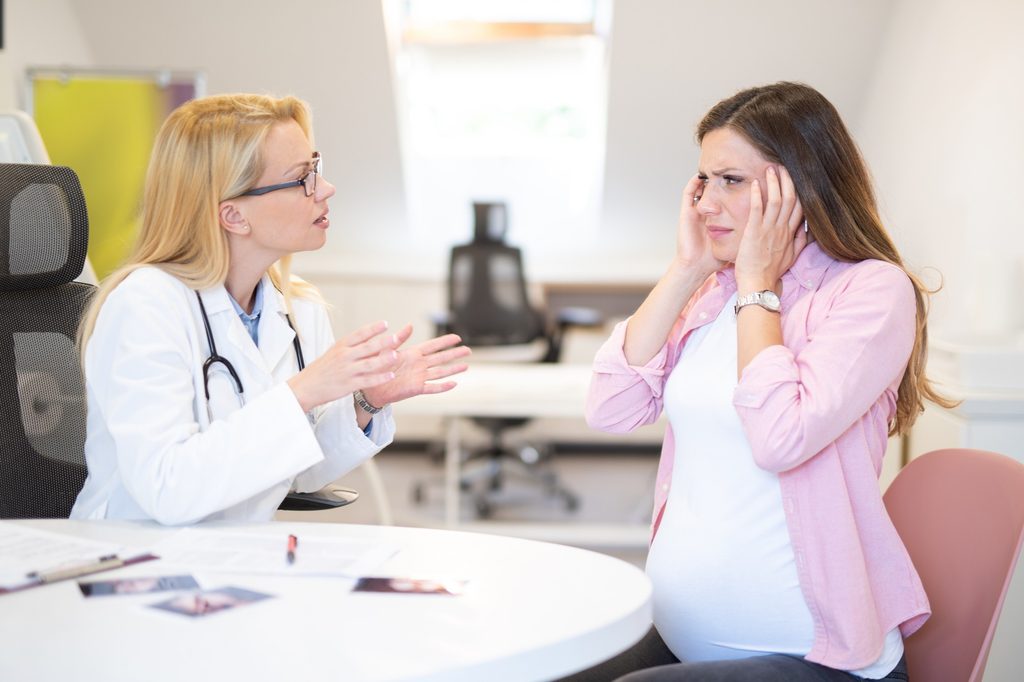Pregnant woman speaking to doctor