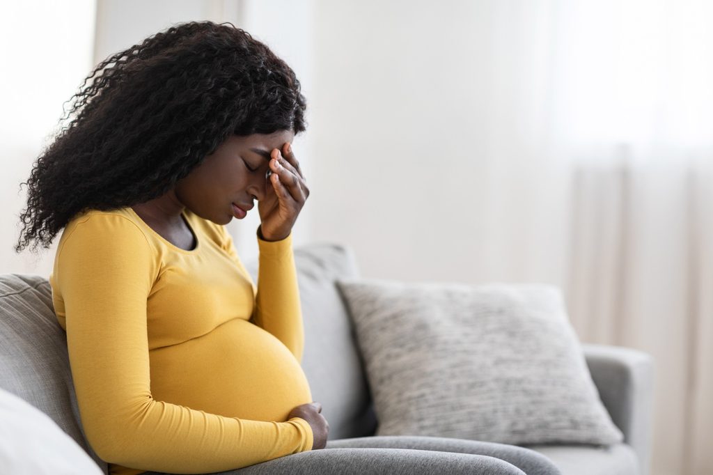 Woman experiencing a painful headache during pregnancy