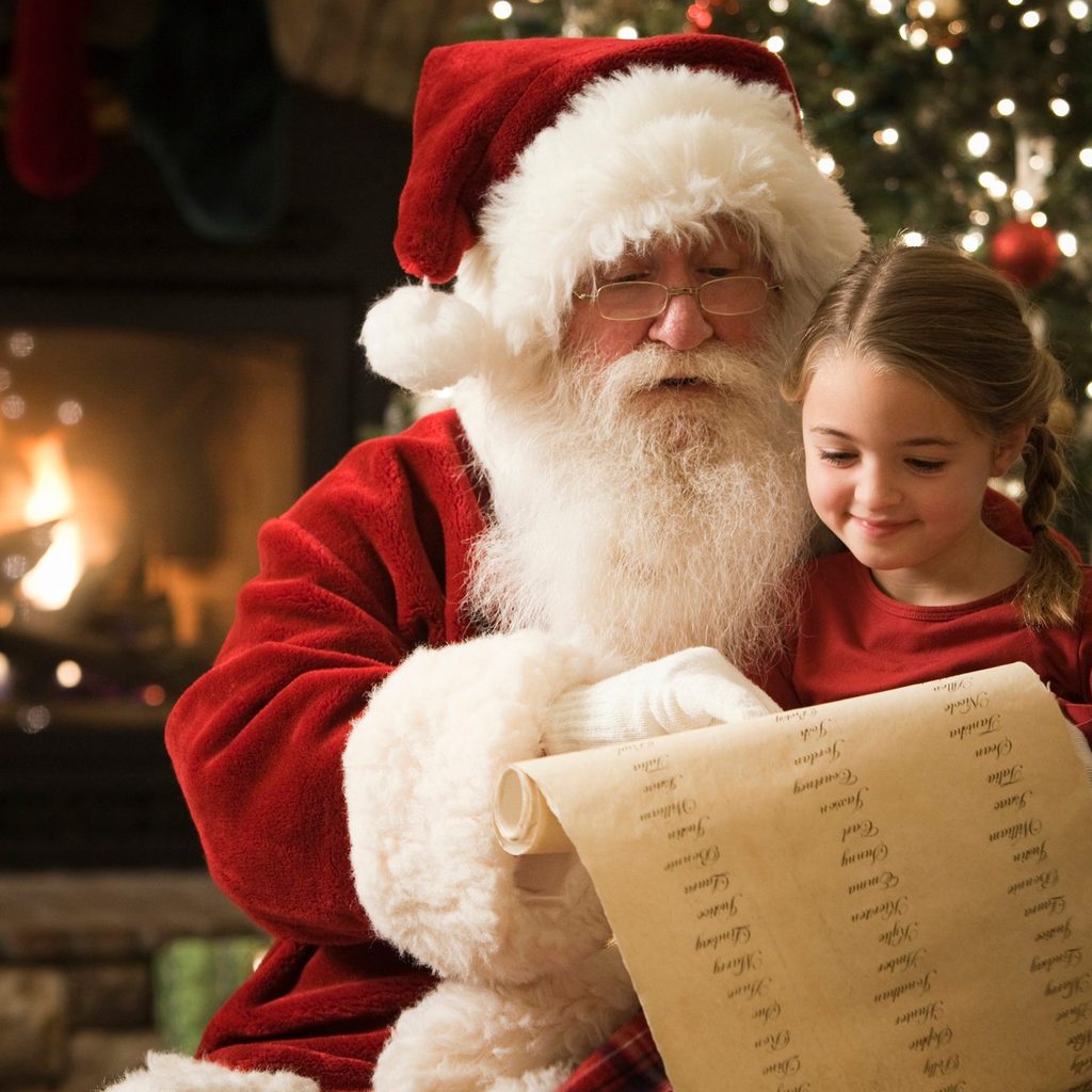 Santa sitting with a little girl going over the list