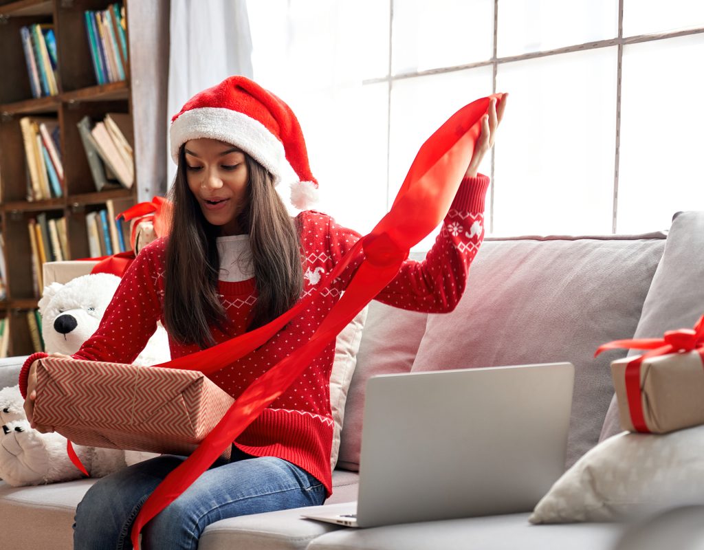 A teenage girl opening a Christmas present.