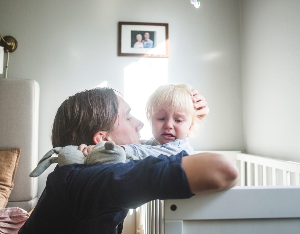 Toddler being comforted in bed after a nightmare.