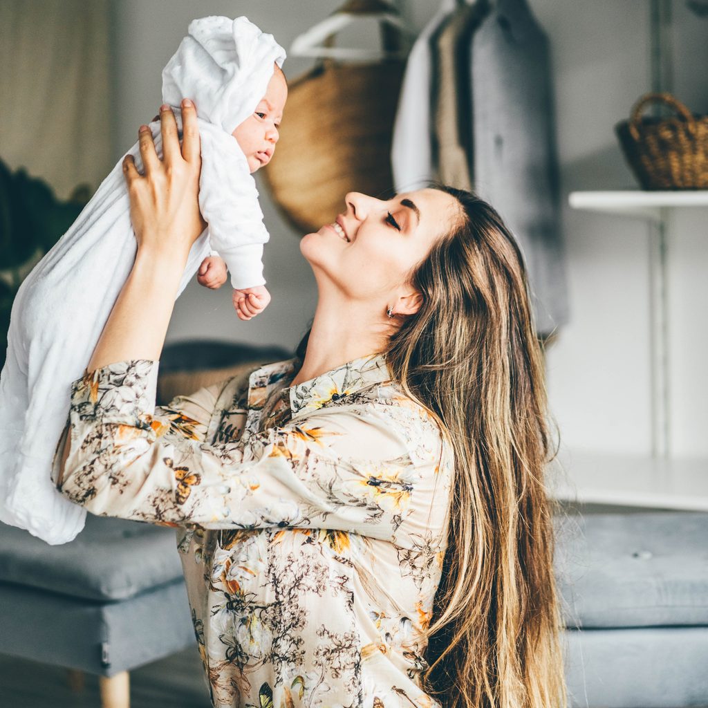 woman with long hair holding baby