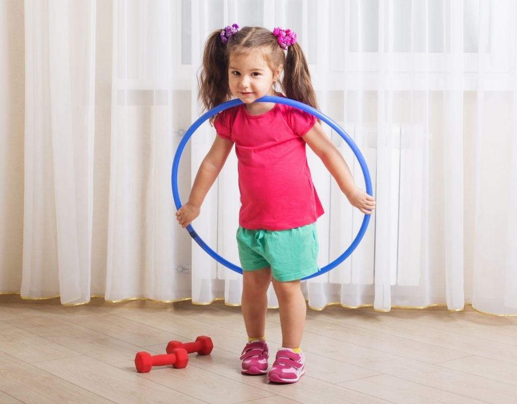 Little girl with hula hoop and weights
