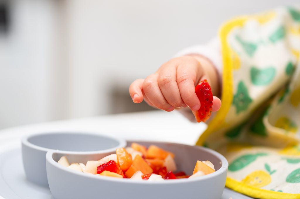baby-hand-eating-snack-fruit-breakfast