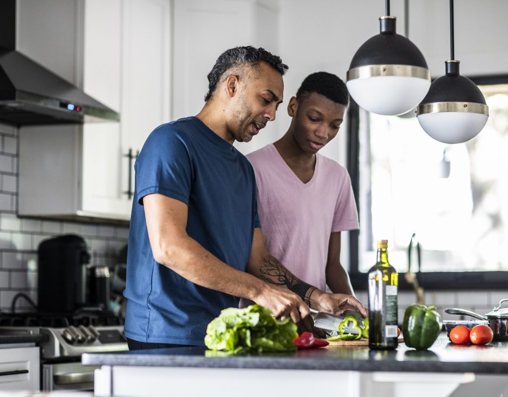 Parent and older child in the kitchen prepping dinner