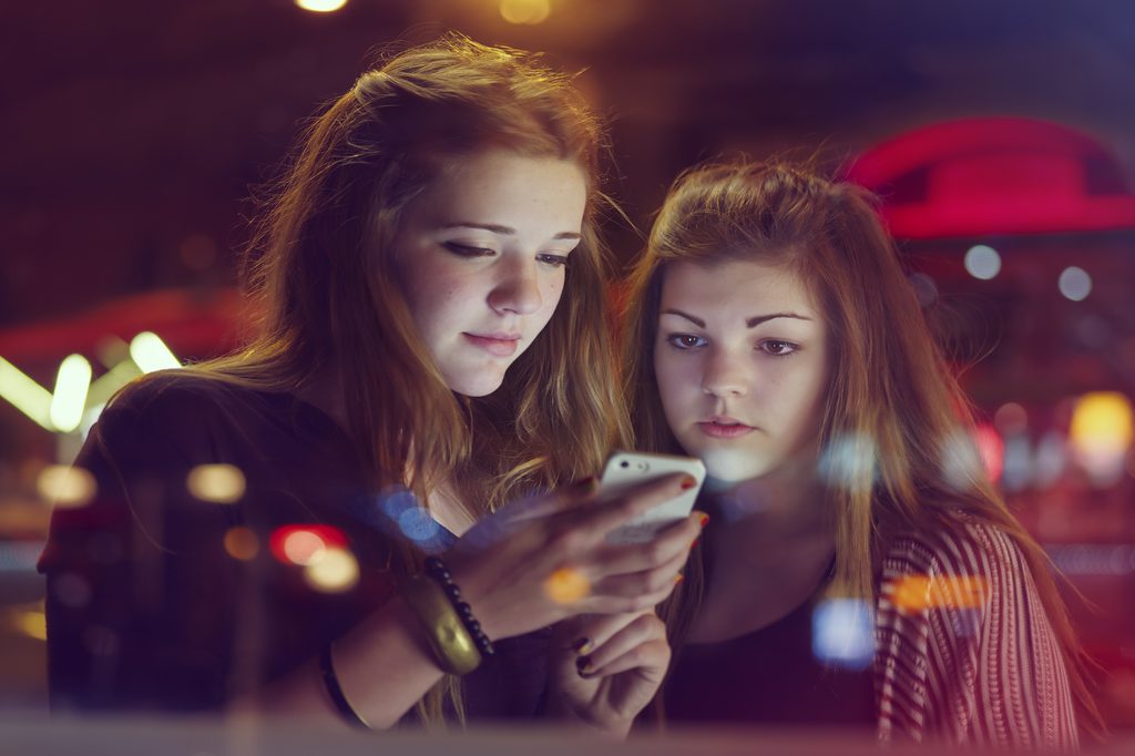 teen-girls-looking-at-phones-and-tiktok