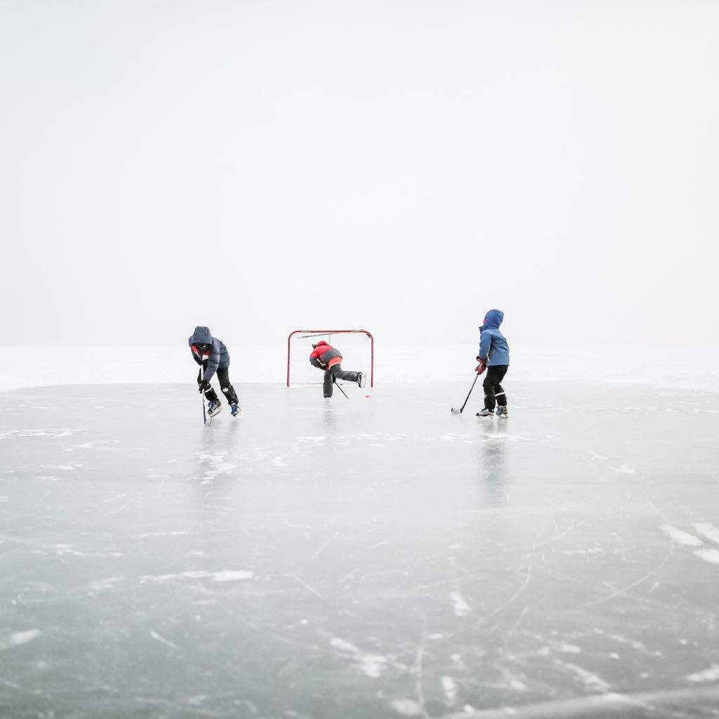 Kids playing ice hockey on outdoor rink