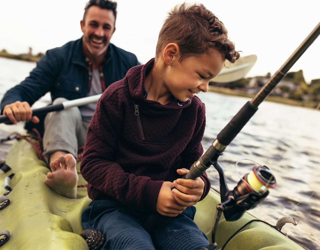 father and son in a kayak fishing