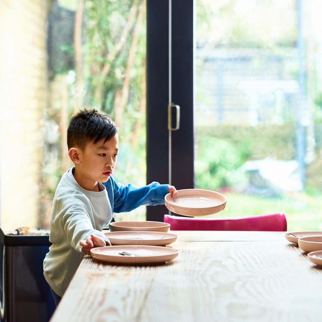 Young boy setting table for lunch