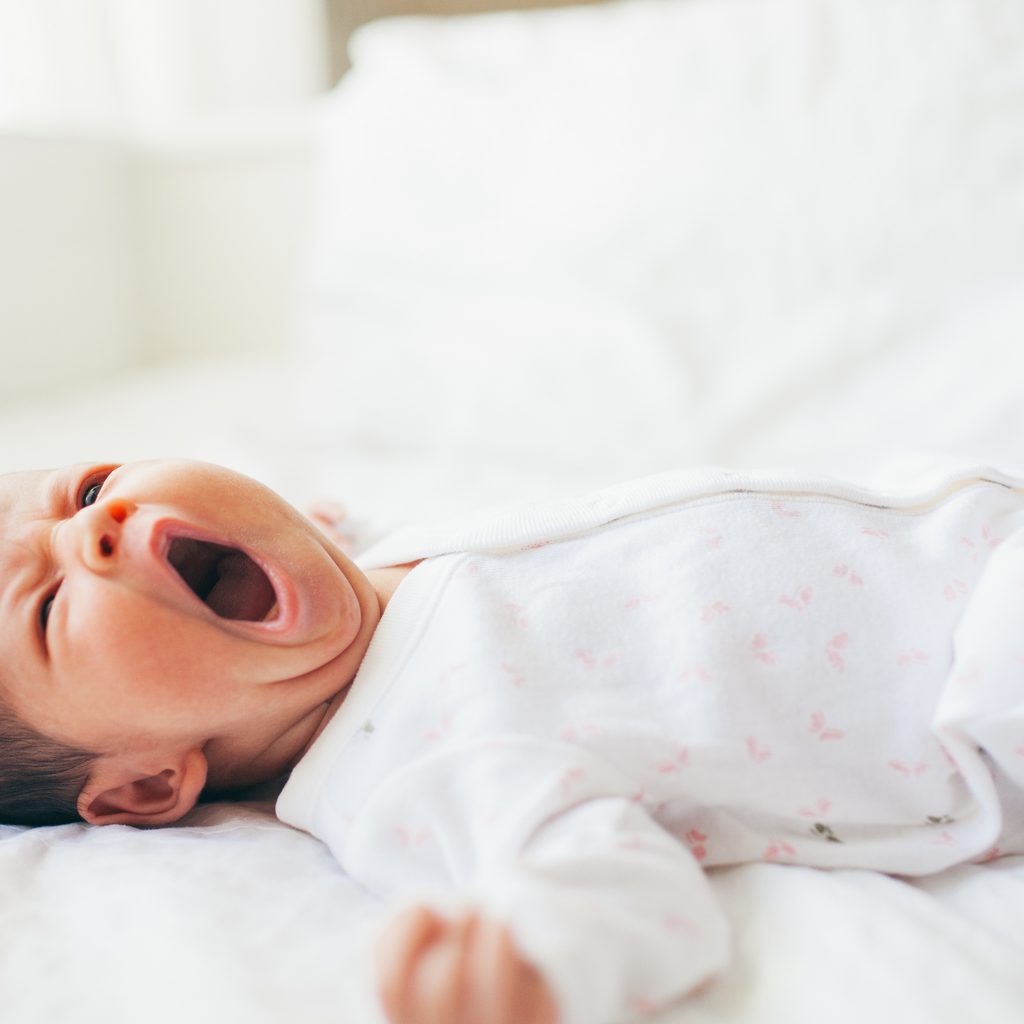 Baby yawning in crib