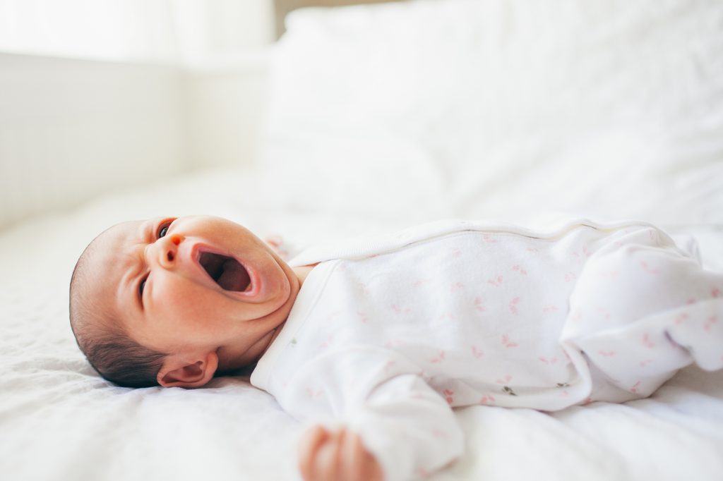 Baby yawning in crib