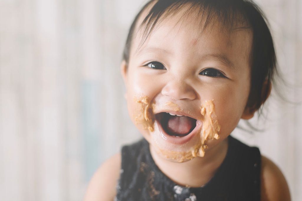 Baby with peanut butter on their face