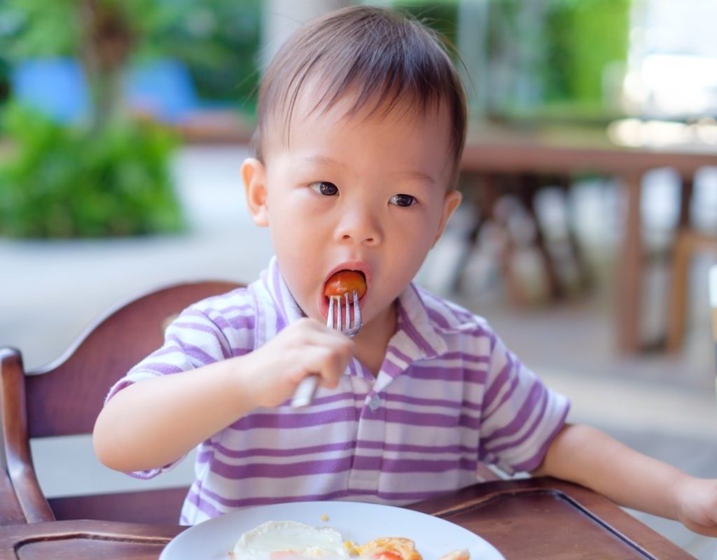asian baby eating tomato