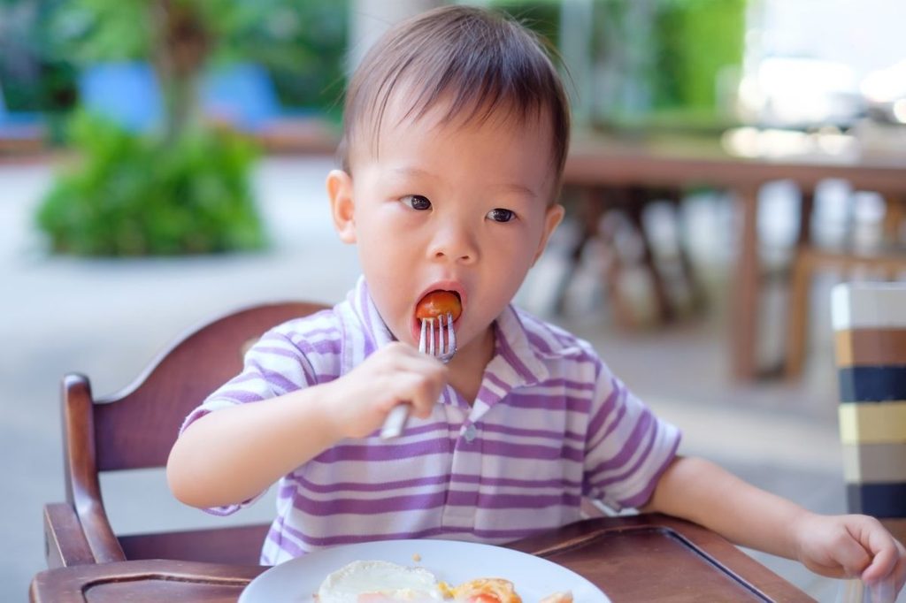 asian baby eating tomato