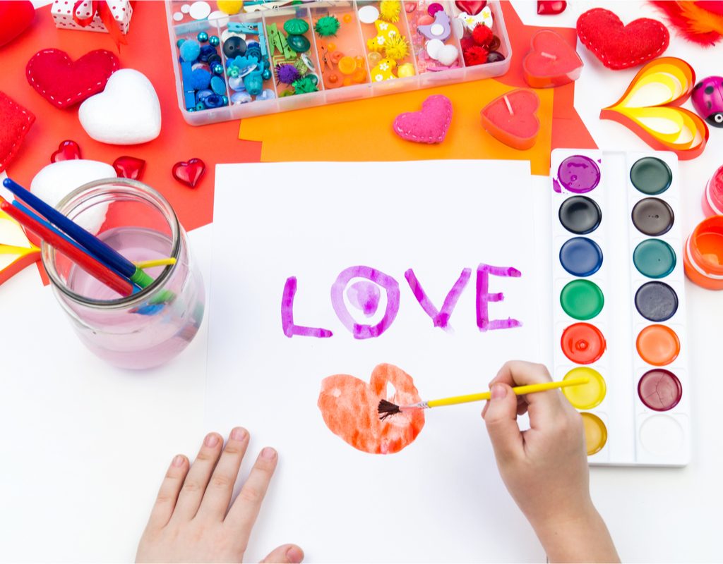 child painting a picture for Valentine's Day