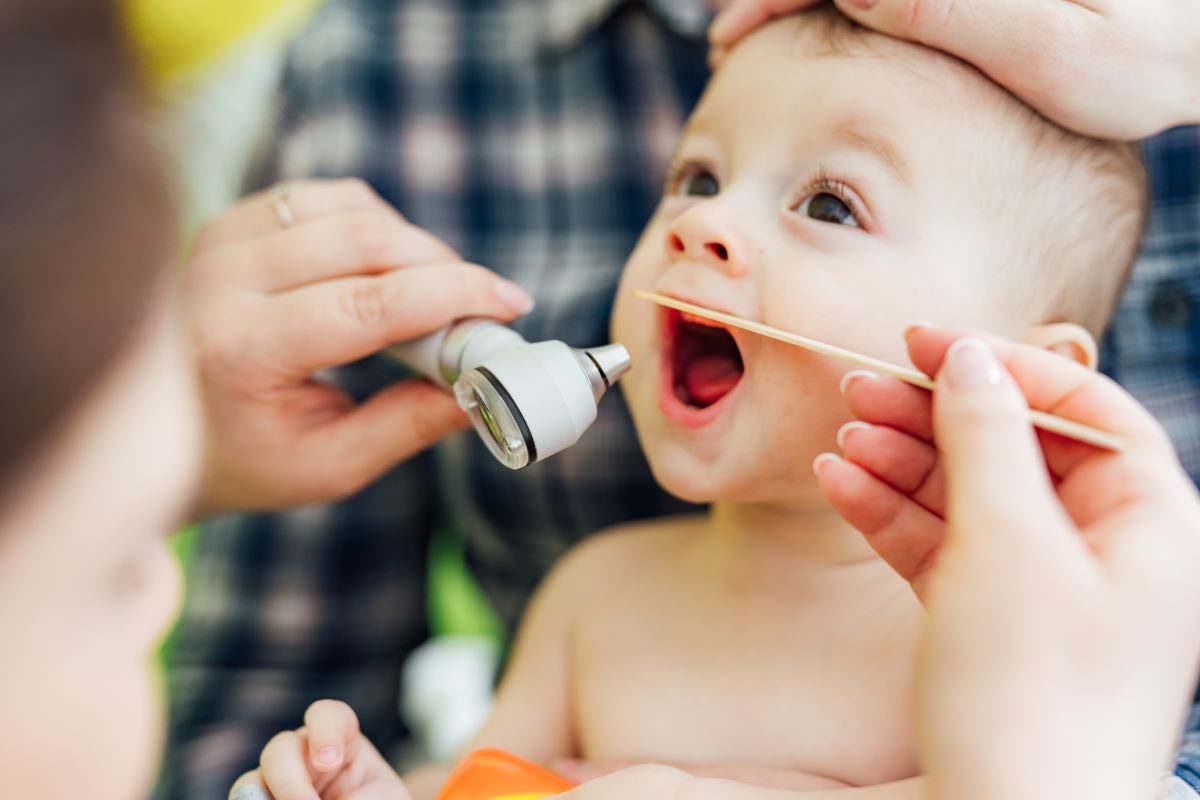 Doctor checking baby's mouth.
