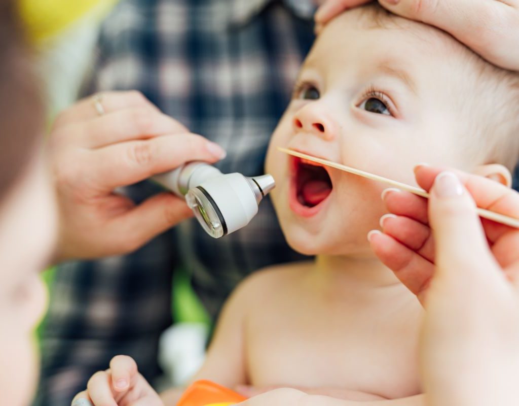 Doctor checking baby's throat